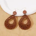 Detail of bohemian teardrop wood earrings with leopard hollow pattern and gold hooks - Brown