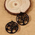 Laser-cut wooden Tree of Life earrings with gold-tone hooks on natural rustic background - Black