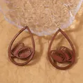 Laser-cut walnut wood teardrop earrings featuring American football cutout design - Brown