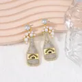 Detailed view of champagne bottle drop earrings with faux pearls and sparkling crystals - Pearl White