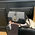 Minimalist black and white saddle bag with golden buckle and sleek leather shoulder strap - Black