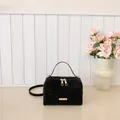 Elegante bolso de mano tipo caja negro mate con herrajes dorados y correa ajustable - Negro