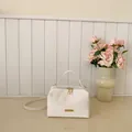 Elegante bolso de mano blanco tipo caja con herrajes dorados y correa ajustable - Blanco