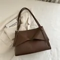 Minimalist dark brown leather tote bag with geometric fold design and silver buckle - Brown