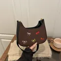 Brown suede crescent underarm bag with colorful embroidered bows and black leather strap - Coffee