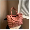 Close-up of soft pink quilted puffer tote bag with waterproof nylon texture and stitching - Pink