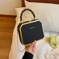 Elegant black and gold box clutch bag with chain strap and twisted top handle - Black