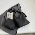 Ensemble sac cabas et pochette en cuir noir grainé avec boucle dorée sur blazer gris - Noir
