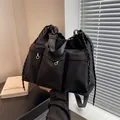 Minimalist black nylon crossbody bag with multi-pocket cargo design and drawstring - Black