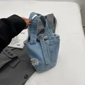 Mini-Eimerhandtasche aus hellblauem Denim mit Used-Effekt und ausgefransten Kanten - Hellblau