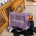 Minimalist purple mesh tote bag with white text print on a rustic wooden background - Purple