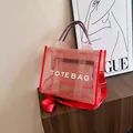 Red mesh tote bag with white TOTE BAG lettering and adjustable crossbody strap - Red
