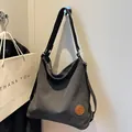 Versatile black canvas hobo tote bag with multifunctional straps and a minimalist design - Black