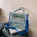 Light blue transparent mesh tote bag with white TOTE BAG text and navy straps - Blue