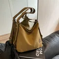 Versatile khaki canvas tote bag with round leather patch on a modern sofa - Khaki