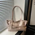 Detail of light pink faux leather bag showing adjustable buckle straps and metal eyelets - Pink