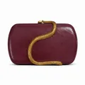 Detailed view of burgundy leather clutch with a prominent golden snake metal decoration - Burgundy