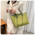 Grüne Tweed-Beuteltasche mit silberner Kette, getragen von einem Modell in Freizeitmode - Grün