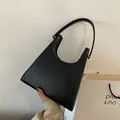 Borsa sottobraccio in pelle nera minimalista con un esclusivo design geometrico a forma di U - Nero