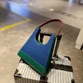 Sac sous le bras rétro en bleu, vert et rouge posé sur une valise argentée chic - Bleu