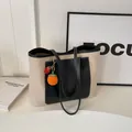 Minimalist canvas tote bag in off-white and black leather with orange persimmon charm - No Pendant / Black