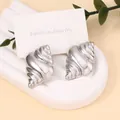 Silver vintage seashell stud earrings with spiral texture on a stone display base - Mirror Silver 3D Conch Style (Style J)