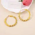 Detail of yellow polymer clay bead hoop earrings with golden spacers in bohemian style - Yellow