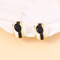 Macro shot of retro oval earrings with black white striped enamel and faceted gems - Round Black Gem Style / Black White Gold Stripe