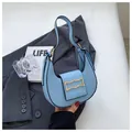 Chic light blue crescent shoulder bag with a gold decorative buckle and black edge detail - Blue