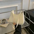 Minimalist beige crescent shoulder bag with detailed stitching and sleek faux leather finish - White