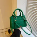 Grüne Handtasche mit Krokodilprägung, Doppelgriffen und goldfarbenen Beschlägen - Grün