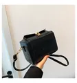 Bolso bandolera retro negro con textura de ondas y cierre dorado en la mano - Negro