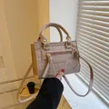 Kleine beige Handtasche mit Krokodilprägung, Goldteilen und dekorativer Quaste - Khaki