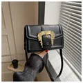 Elegante bolso de mano en cuero negro con hebilla barroca dorada y asa superior chic - Negro