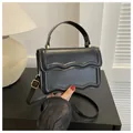 Classic black square handbag with elegant wave pattern embossing and gold hardware - Black