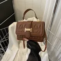 Schicke braune Stepphandtasche mit goldenem H-Verschluss und verstellbarem Schultergurt - Braun