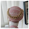 Detalle del bolso redondo de baloncesto rosa con cadena dorada y textura de piel - Rosa