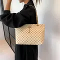 Fashion tote bag with geometric print and golden deer charm on elegant chain shoulder strap - White