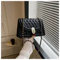 Classic black quilted crossbody bag with golden chain strap and elegant twist lock - Black