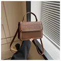 Bolso bandolera marrón con grabado de cocodrilo, tachuelas doradas y asa de mano - café