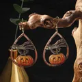 Macro view of wooden Halloween earrings featuring a skull hand holding a pumpkin lantern - Skeleton Hand Pumpkin Style