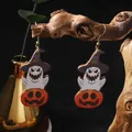Macro detail of wooden Halloween ghost and pumpkin earrings on a rustic branch - Wizard Hat Style / Purple Witch Hat Ghost Pumpkin