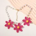 Dettaglio collana margherita in rafia rosa tessuta con perle e catena dorata - Collana Rosso Rosa