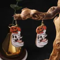Close-up of wooden Halloween ghost and pumpkin earrings hanging on a natural branch - Tongue Style / Tongue Out Ghost With Pumpkin