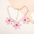 Dettaglio collana di perle con fiori di margherita in raffia rosa e chiusura dorata - Collana Rosa