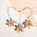Dettaglio macro della collana con margherite tessute colorate e perle bianche - Collana Multicolore