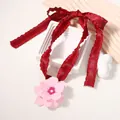Close-up of pink layered flower pendant on a burgundy pleated satin ribbon bow - Pink Flower Red Ribbon / Red