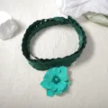 Close-up of green fabric ribbon necklace featuring a blue enamel flower pendant with silver edges - Cyan Flower Green Ribbon / Green