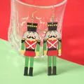 Pendientes de madera de cascanueces coloridos sobre un fondo festivo rojo y verde - Verde