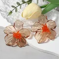 Modieuze amberkleurige acryl bloemoorsteker met oranje kralen hart voor dames - Bruin